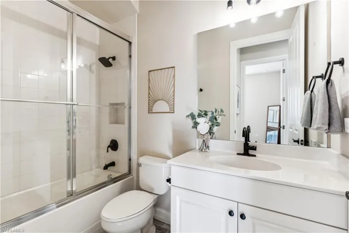 Bathroom featuring vanity and shower / bath combination with glass door