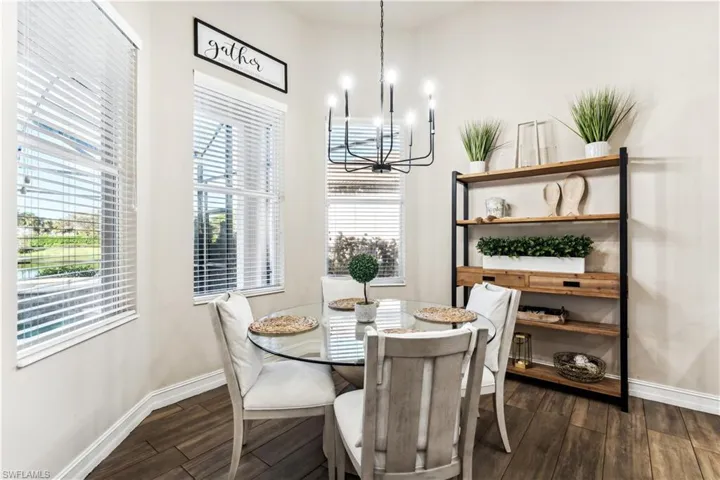 Dining room with dark wood-style floors and a chandelier
