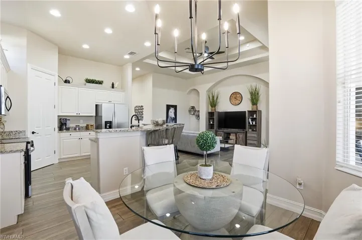 Dining room featuring arched walkways, suspended lighting, and light wood finished floors