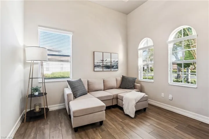 Sitting room featuring dark wood-type flooring and plenty of natural light