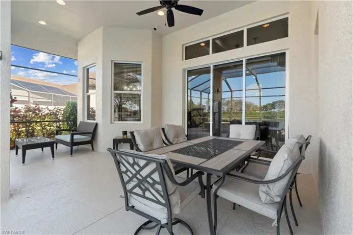 View of patio featuring a sunroom, a ceiling fan, outdoor dining space, and a lanai