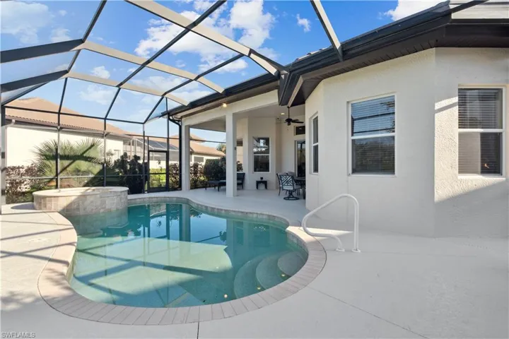 View of pool featuring a patio, a sunroom, glass enclosure, a ceiling fan, and a pool with connected hot tub