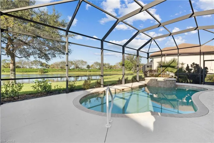 Swimming pool with glass enclosure, a sunroom, and a water view