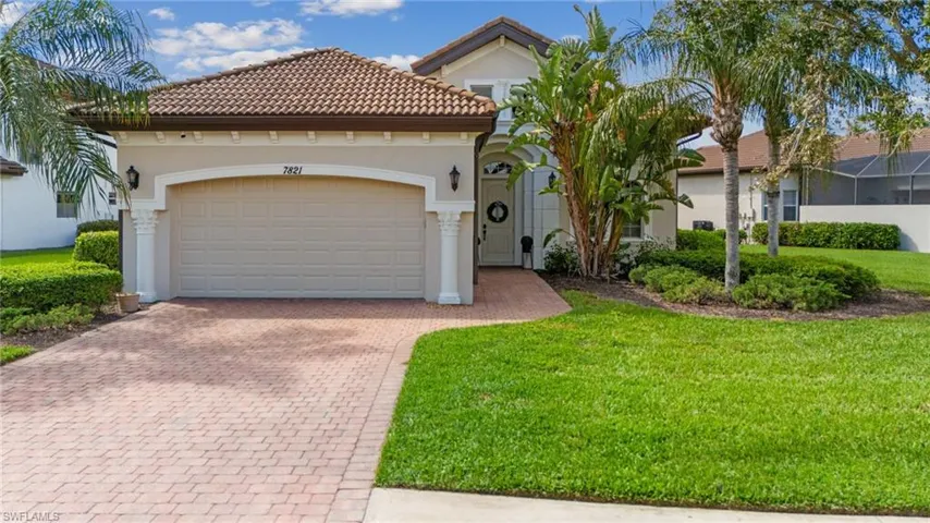 Mediterranean / spanish house with decorative driveway, an attached garage, stucco siding, a tile roof, and a front lawn