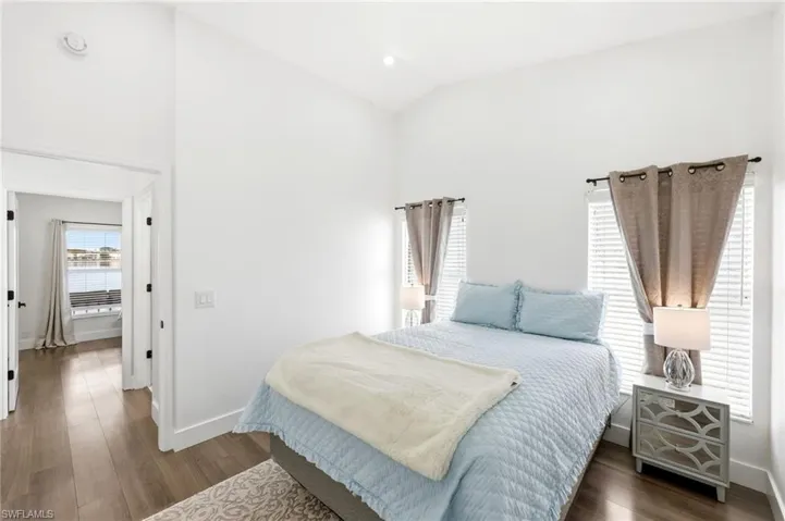 Bedroom with dark wood-style flooring and vaulted ceiling