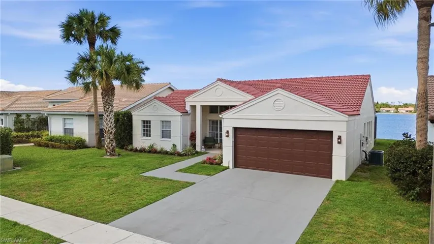 View of front of home featuring stucco siding, a front yard, and driveway