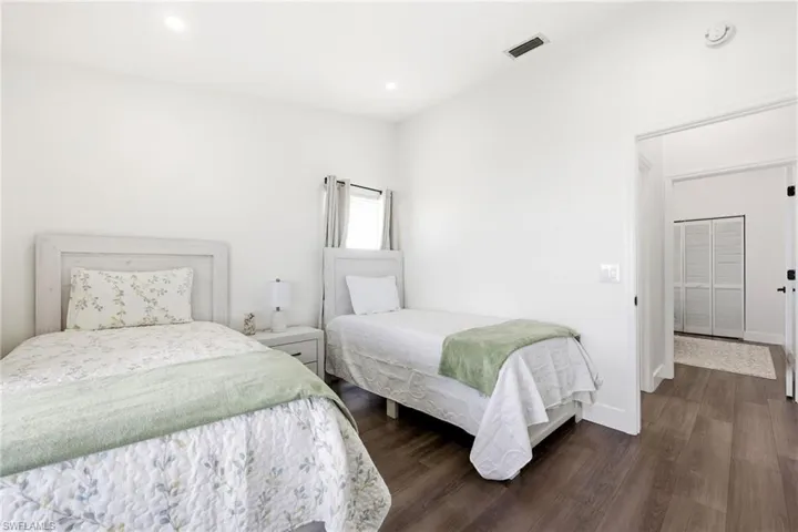 Bedroom with dark wood finished floors and recessed lighting