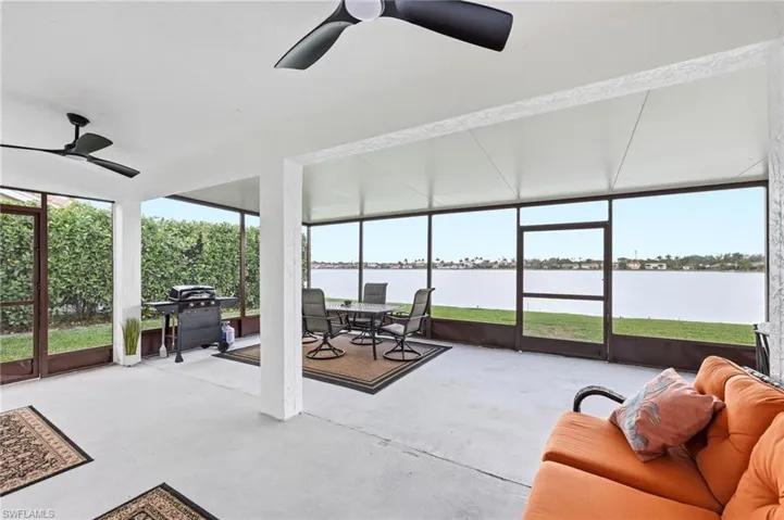 Sunroom / solarium with ceiling fan, outdoor dining area, and a water view