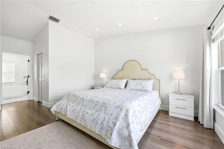 Bedroom featuring dark wood-type flooring, recessed lighting, and lofted ceiling