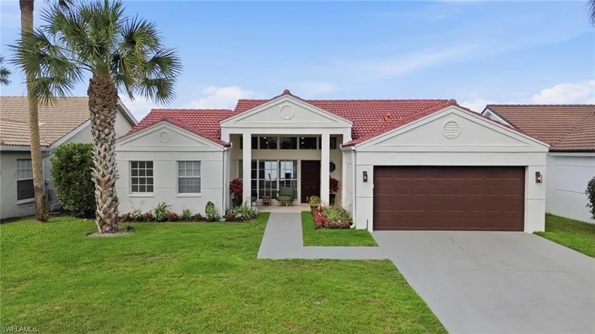 View of front of property with a garage, stucco siding, a front lawn, concrete driveway, and a tile roof