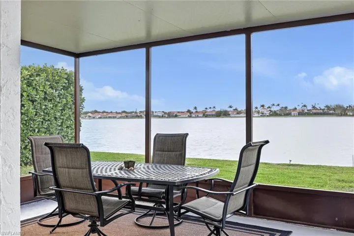 Sunroom with outdoor dining space and a water view