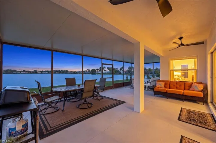 Sunroom / solarium with a water view, expansive windows, healthy amount of natural light, and concrete flooring