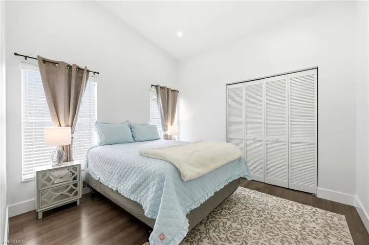 Bedroom with a closet, vaulted ceiling, and dark wood-type flooring