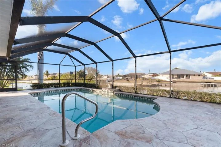 View of swimming pool featuring glass enclosure and a patio