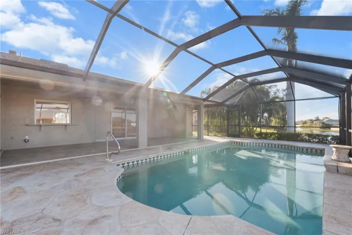 View of swimming pool featuring a patio and glass enclosure