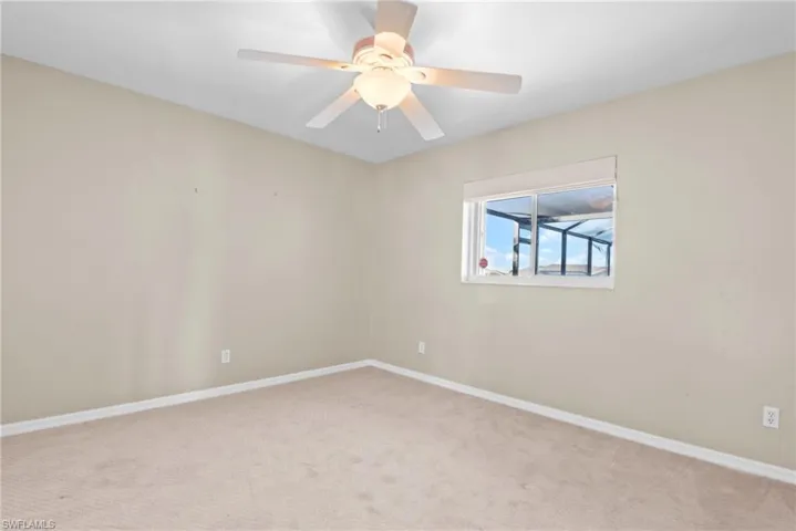 Empty room featuring light colored carpet and ceiling fan