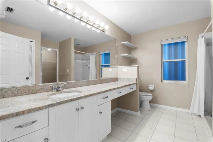 Bathroom featuring tile patterned flooring, vanity, and toilet