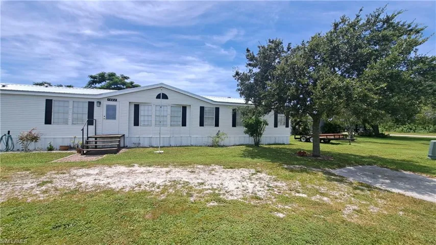 Manufactured / mobile home with a front yard and a metal roof