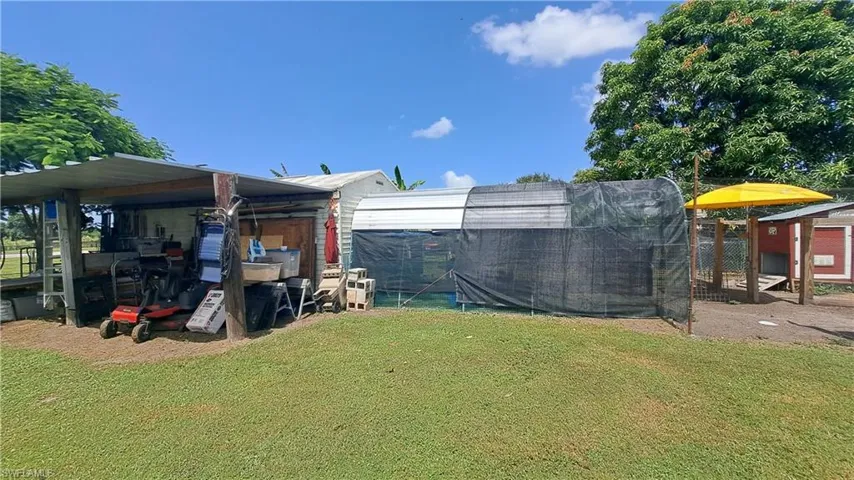 View of green lawn featuring exterior structure and an outdoor structure