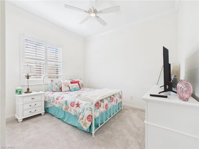 Bedroom with light carpet, ornamental molding, and a ceiling fan