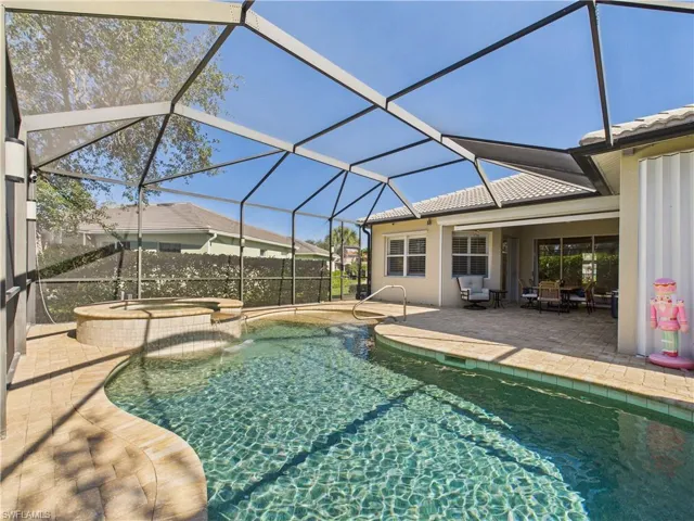 View of pool with a patio area, a sunroom, a pool with connected hot tub, and a lanai