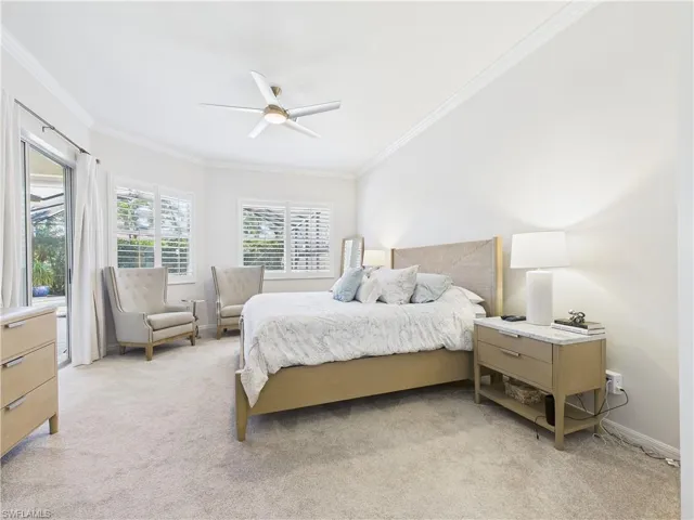 Bedroom with crown molding, light colored carpet, and ceiling fan