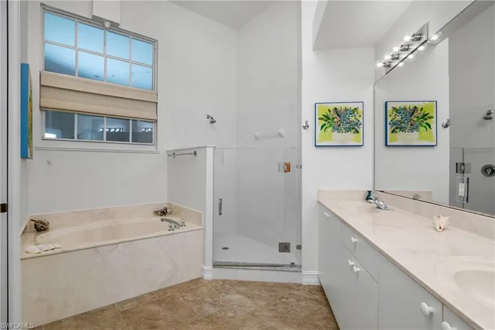 Bathroom with independent shower and bath, tile patterned floors, and double vanity