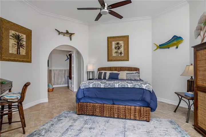 Bedroom featuring ornamental molding, tile patterned flooring, and ceiling fan