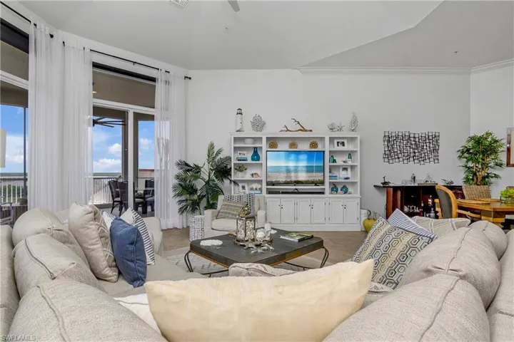 Tiled living room with crown molding and ceiling fan