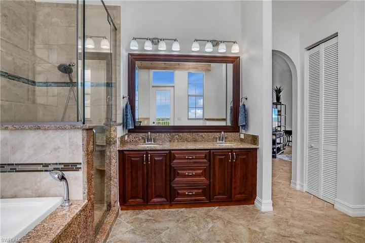 Bathroom featuring tile patterned flooring, independent shower and bath, and dual bowl vanity