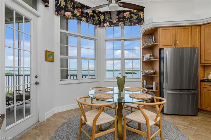 Tiled dining room with a water view and ceiling fan