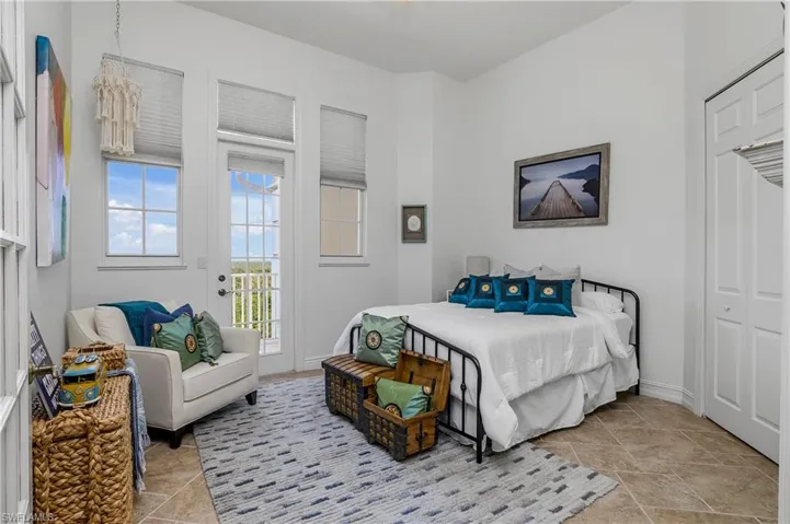 Bedroom with a closet, access to exterior, and light tile patterned floors