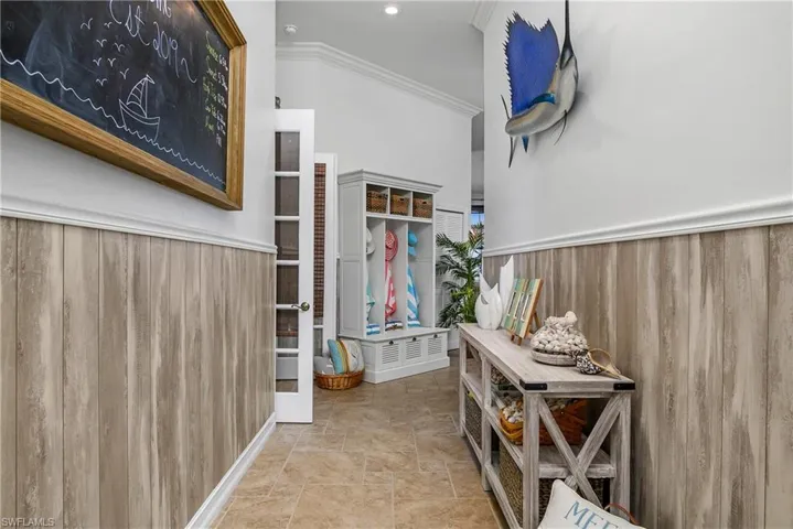 Hallway featuring light tile patterned flooring and ornamental molding