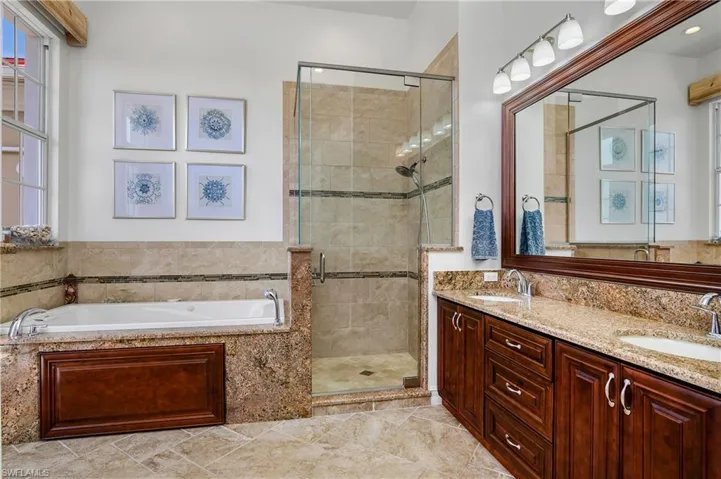 Bathroom featuring shower with separate bathtub, tile patterned flooring, and dual bowl vanity