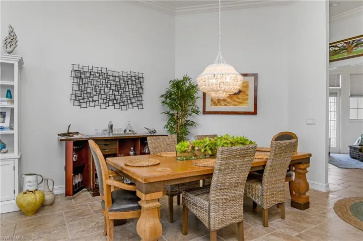 Tiled dining space with ornamental molding and a chandelier