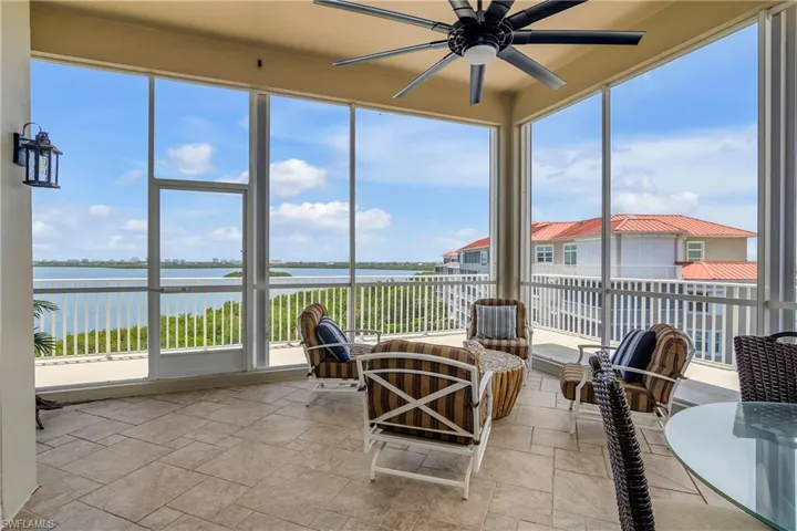 Sunroom / solarium with plenty of natural light, a water view, and ceiling fan