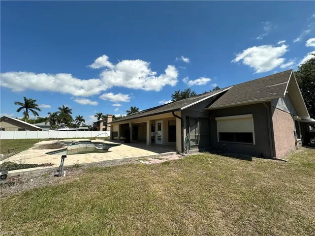 Rear view of property with a fenced in pool, a patio area, a yard, and a fenced backyard
