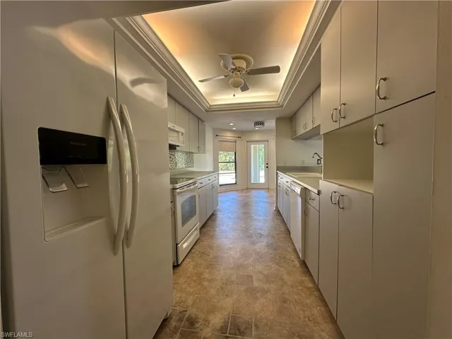 Numerous Cabinets across from the Refrigerator is a Large Pantry located to the Right