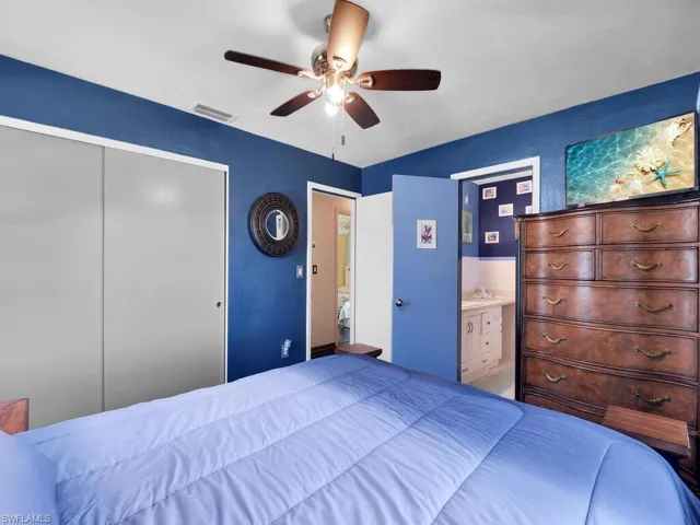 Bedroom with connected bathroom, ceiling fan, and a closet