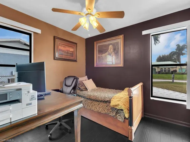 Bedroom with multiple windows, hardwood / wood-style floors, and ceiling fan