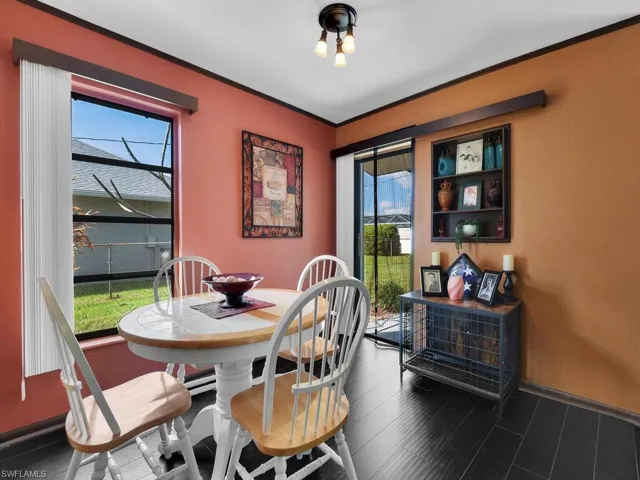 Dining room with dark wood-type flooring and crown molding