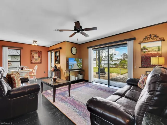 Living room featuring dark hardwood / wood-style flooring and ceiling fan