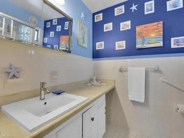 Bathroom featuring tile walls, vanity, and tile patterned floors