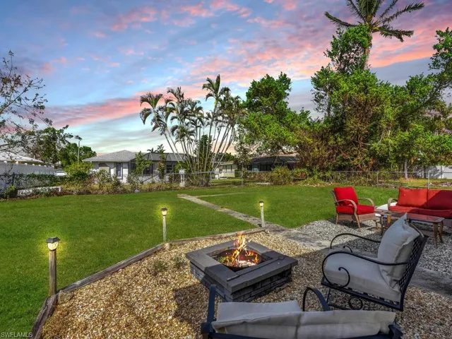Yard at dusk with an outdoor living space with a fire pit and a patio area