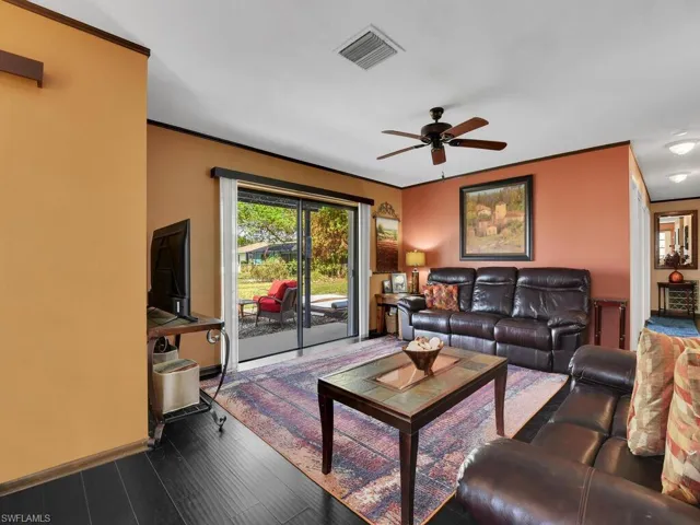 Living room featuring dark hardwood / wood-style flooring and ceiling fan