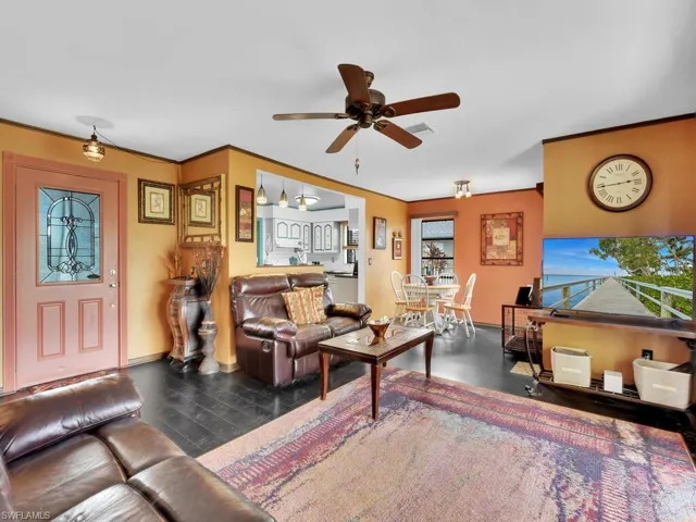 Living room featuring ceiling fan and dark hardwood / wood-style flooring