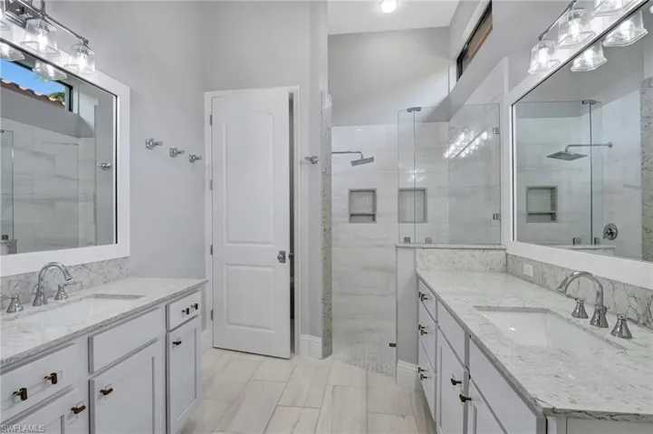 Remodeled Master Bathroom featuring dual vanities and a walk-in shower