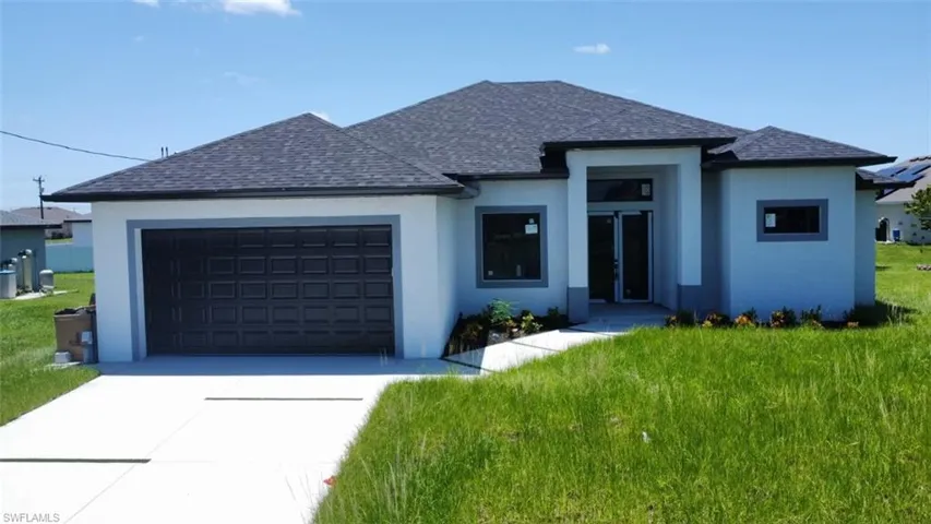 View of front of house featuring a garage and a front yard