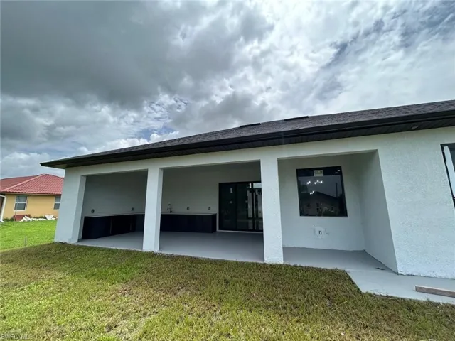 Back of property with a patio and a lawn