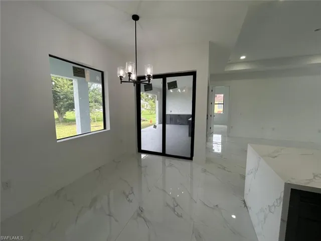 Unfurnished dining area with tile patterned flooring and a chandelier